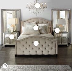 a white bed sitting under a chandelier next to two mirrored tables and lamps