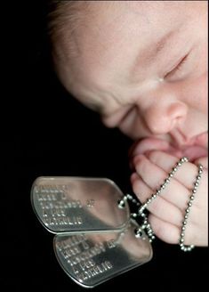 a close up of a baby with a chain on it's hand and a pacifier in his mouth