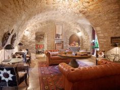 a living room filled with furniture and a stone archway in the middle of it's walls