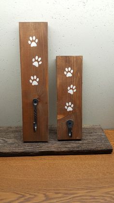 two dog paw prints are on the wooden block and one is holding a bottle opener