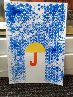 an art project with blue and white paint on paper, the letter j is made out of