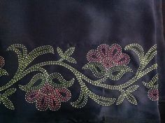 an embroidered black cloth with pink flowers on it