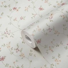 a white wallpaper with pink flowers on it and a roll of tape next to it