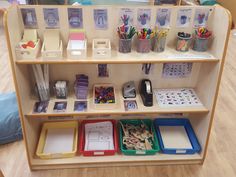 a wooden shelf filled with lots of different types of stationery and pencils on top of it