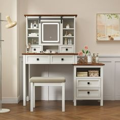 a white desk with two drawers and a mirror above it, in a room with hard wood flooring