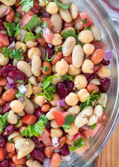 a bowl filled with beans and cilantro on top of a wooden table