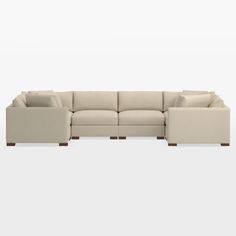 a large sectional couch with pillows on the top and bottom end, in front of a white background