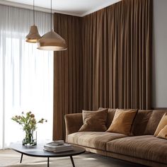 a living room with a couch, coffee table and large window covered in drapes