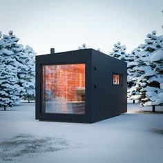 a small black building sitting in the middle of a snow covered field next to trees