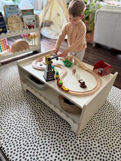 a young boy playing with a toy train set