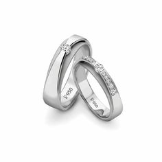 two white gold wedding rings with diamonds on each one and the word love written in cursive writing