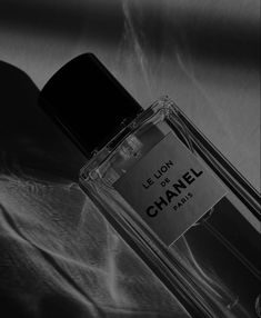 a bottle of chanel le lion eau de toilette sitting on a bed