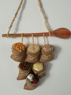 a wooden spoon hanging from a wall with various spices and nuts in burlocks