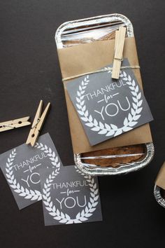 some thank you notes and clothes pins on a black table with brown paper, scissors and other items