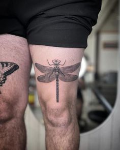 two men with tattoos on their legs, one has a dragonfly and the other has a butterfly