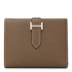 This is an authentic HERMES Epsom Bearn Compact Wallet in Etoupe. This chic wallet is crafted of richly textured calfskin leather in taupe with a border of white stitching, a crossover strap, and a gold-plated Hermes H clasp. The wallet opens to a matching leather interior with a card slot panel, patch pockets, and a small zipper compartment. Hermes Wallet, Compact Wallet, Leather Interior, Style Board, Crossover, Patch Pocket, Calf Skin, Wallets, Gold Plate