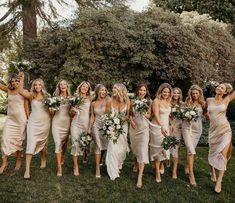 a group of bridesmaids walking in the grass