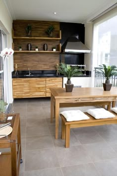 a kitchen with wooden cabinets and counter tops next to a dining room table in front of a large window