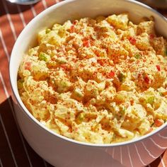 a bowl filled with food sitting on top of a red and white checkered table cloth