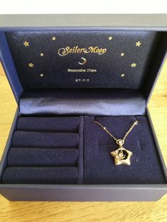 an open box with a necklace in it