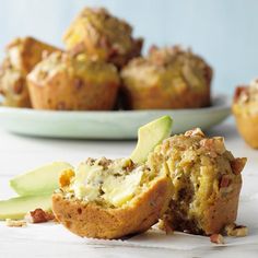 a muffin filled with meat and cheese next to a plate of other food items