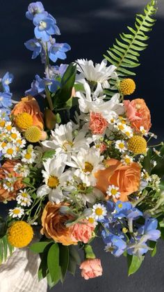 a vase filled with lots of different colored flowers