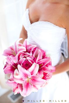 a bride holding a bouquet of pink flowers