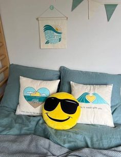 a smiley face pillow sitting on top of a bed