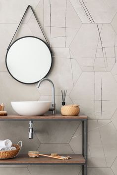 a bathroom sink with a mirror above it and a bowl on the counter next to it