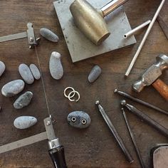 some tools are laying out on a table with rocks and hammers next to them