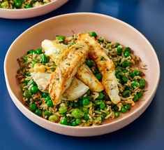 two bowls filled with rice, peas and chicken on top of a blue tablecloth