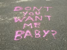 some pink chalk writing on the ground in front of a parking lot that says, don't you want me baby?