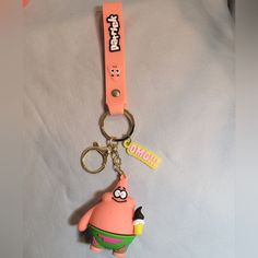 a pink keychain with a cartoon character on it's front and back ends