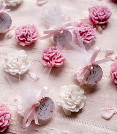 small pink and white flowers are on a tablecloth with tags attached to them that read, i love you