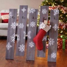 a christmas stocking hanging on the side of a wooden fence with snowflakes