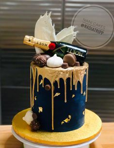 a cake decorated with chocolates, champagne and other items on top of a table