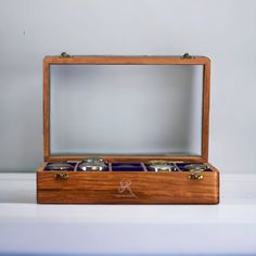 an open wooden box with four rings inside