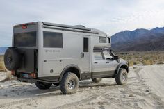 an off - road vehicle is parked in the desert