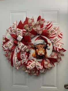 a christmas wreath with a dog wearing a santa hat on it's front door