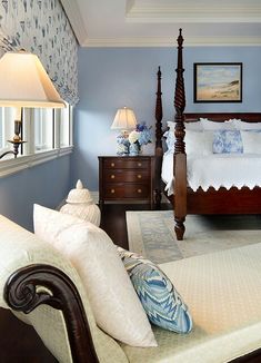 a bedroom with blue walls and white bedding