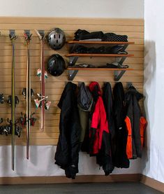 there is a coat rack with skis and snowboards on it in the room