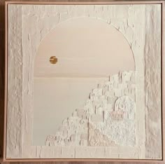 an abstract painting with white paint and gold foil on the edges, in a wooden frame