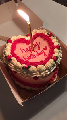 a heart shaped birthday cake with a lit candle