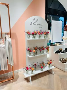 a display case filled with lots of different types of shoes and flowers in vases