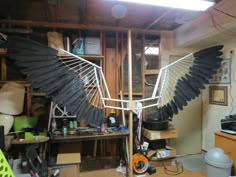 a large bird sculpture sitting on top of a wooden table next to a computer desk