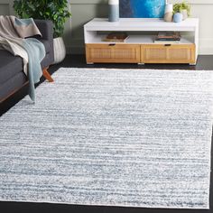 a living room with a gray couch and white rug