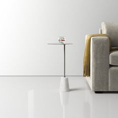 a couch and table in a room with white walls, flooring and lighting on the side