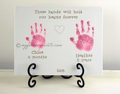 two hand prints on a white card with black stand