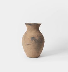 a brown vase sitting on top of a white table