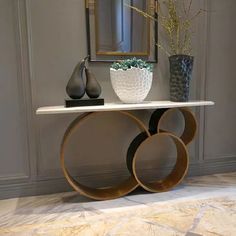 a console table with two vases on it and a mirror in the corner behind it